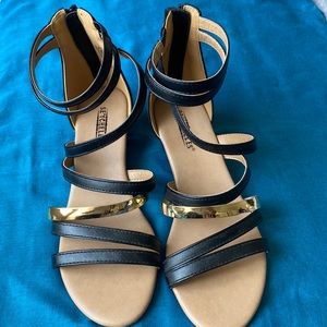 Black & gold sandals that zip in back. 1” heel NEVER been worn. Size 6.5